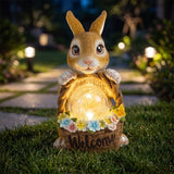 Solar rabbit garden statue with flower basket glowing at dusk